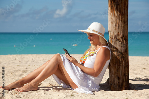 girl with tablet on the beach