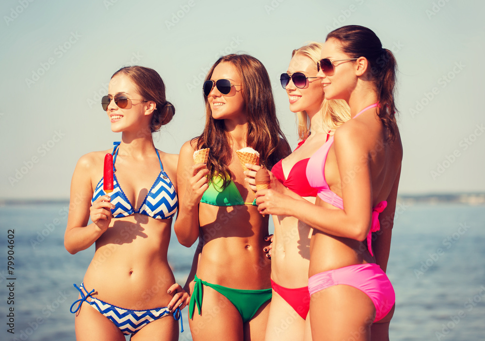 group of smiling women eating ice cream on beach group of smiling women eating ice cream on beach