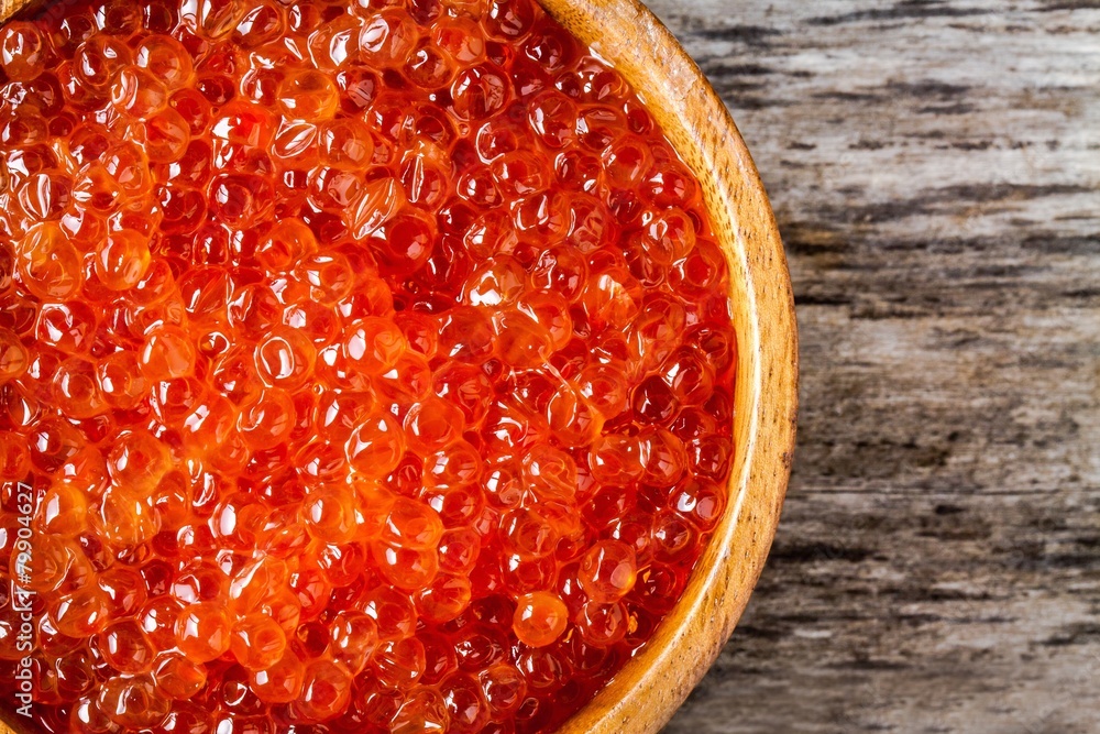 fresh red caviar in a wooden bowl closeup fresh red caviar in a wooden bowl closeup