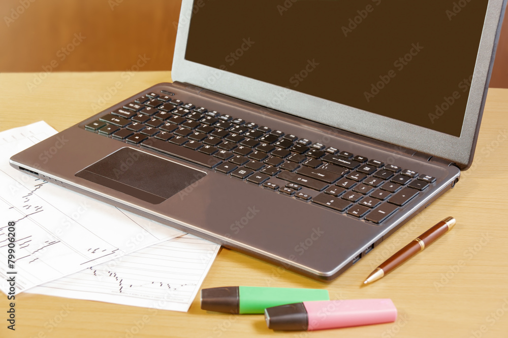 Fototapeta premium Laptop, pen and highlighters on office desk