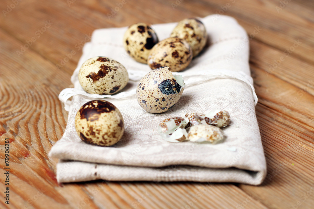 Quail eggs and a napkin lying on a wooden table Quail eggs and a napkin lying on a wooden table