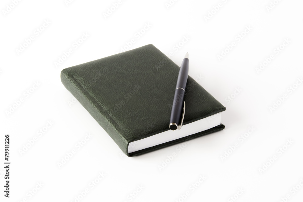 Dark green covered notepad with metallic pen isolated Dark green covered notepad with metallic pen isolated