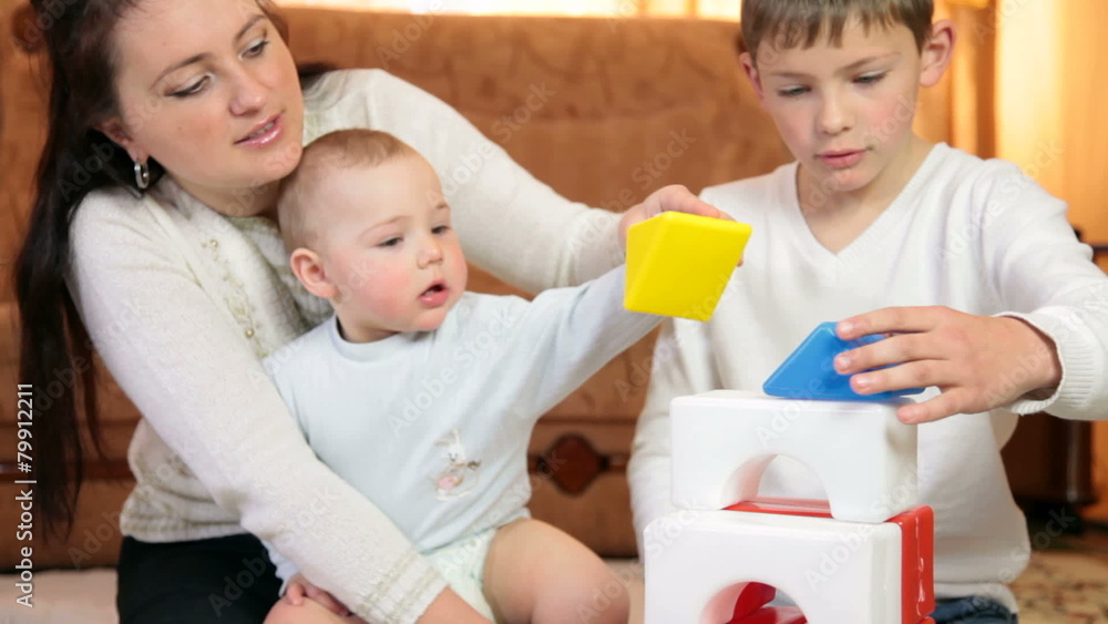 Mother and children playing with colored blocks Mother and children playing with colored blocks