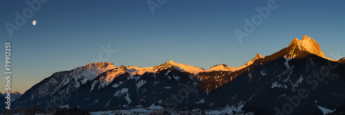 panorama of mountain chain with lighted summits in winter