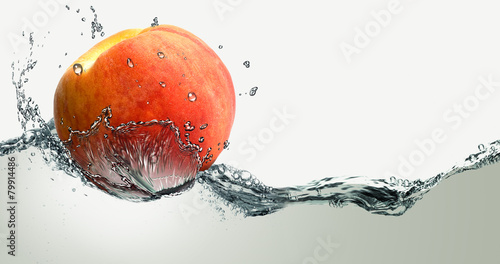 Fotografie Ripe peach and splashes of water.