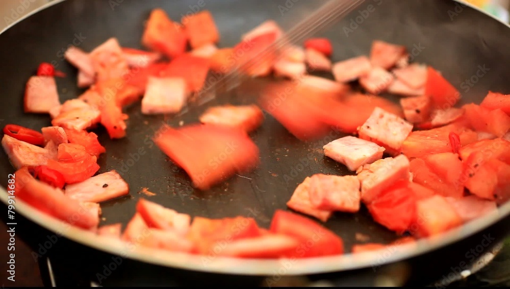 preparing breakfast of eggs, ham, hot peppers and tomatoes in a preparing breakfast of eggs, ham, hot peppers and tomatoes in a