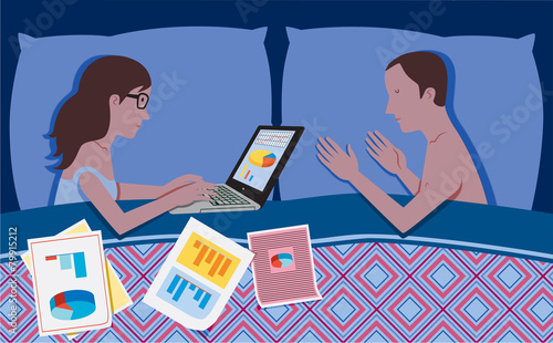 Woman works in bed at night while her partner is sleeping