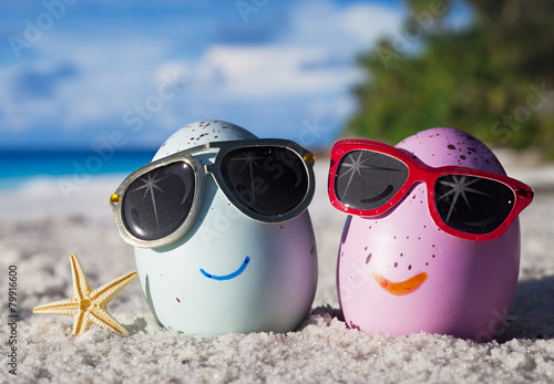 Canvas Print Happy easter eggs with sunglasses on ocean beach