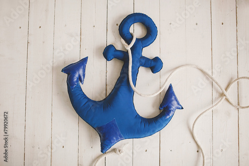 Soft toy blue anchor on wooden beams