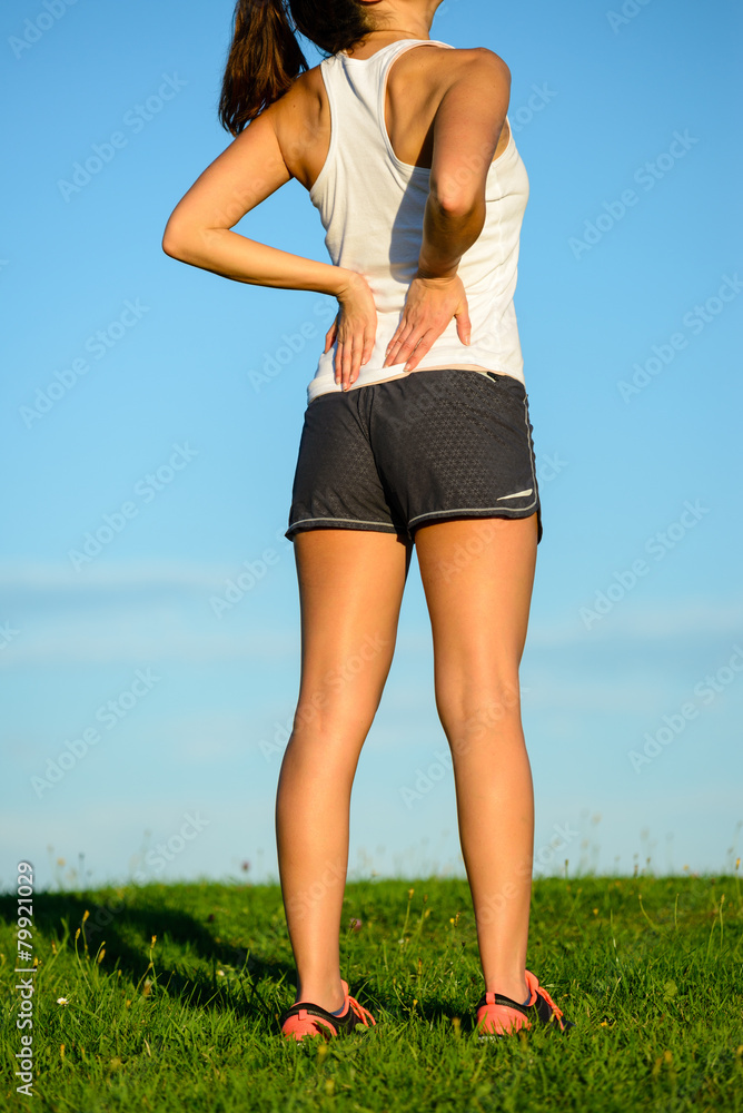 Female athlete suffering low back pain Female athlete suffering low back pain