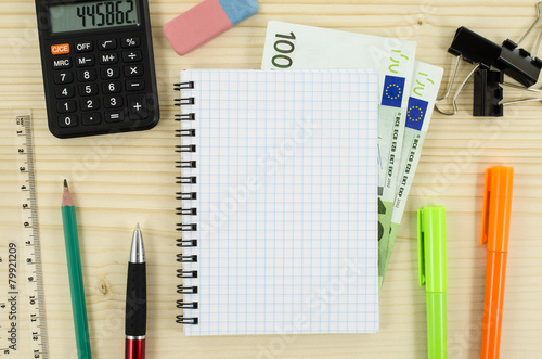 Office, business tools with notebook and euro on wooden table