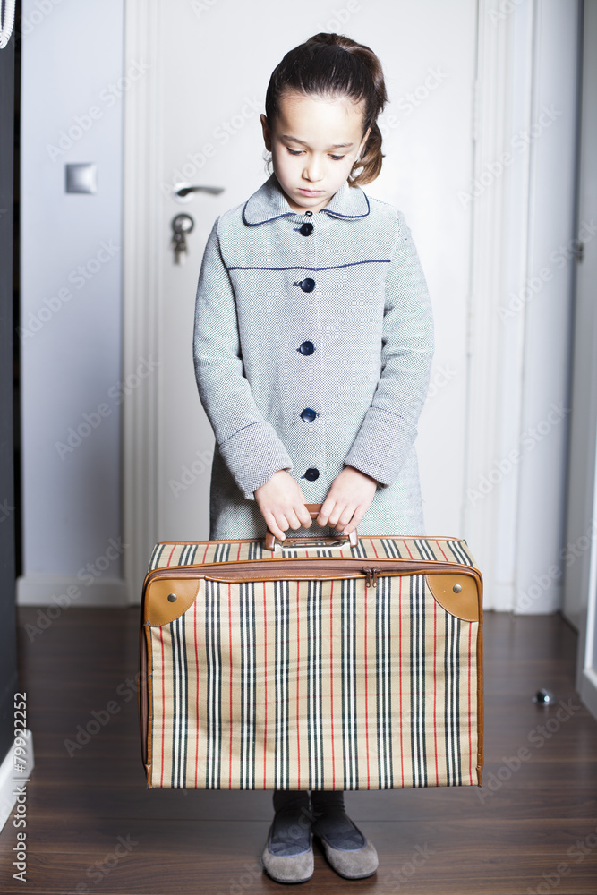 Niña con maleta en la mano y gesto triste Stock Photo | Adobe Stock