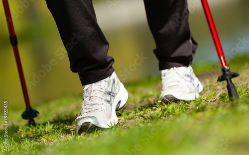 Nordic walking. Female legs hiking in the park. © Voyagerix