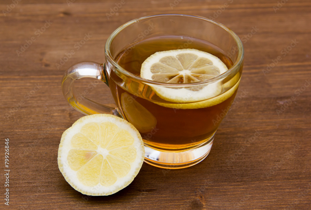 Tea with lemon on cup on wooden table Tea with lemon on cup on wooden table