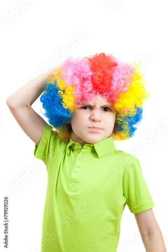 Portrait of angry boy in a colorful wig
