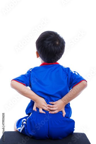 Back pain. Child rubbing the muscles of his lower back