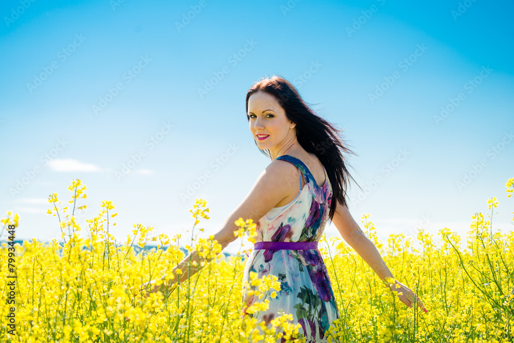 Fototapeta premium Young woman in rapeseed field
