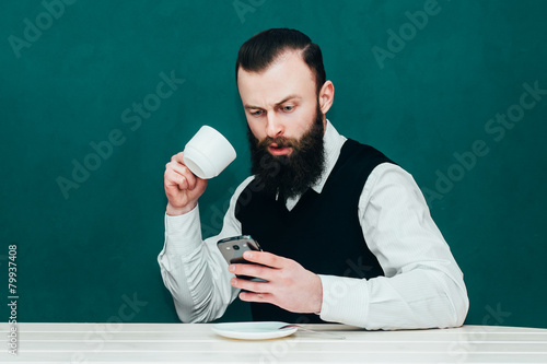 Businessman writes a message , holding a mug of coffee. photo