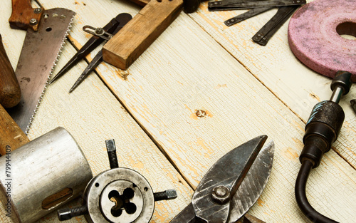 Vintage working tools on wooden background.