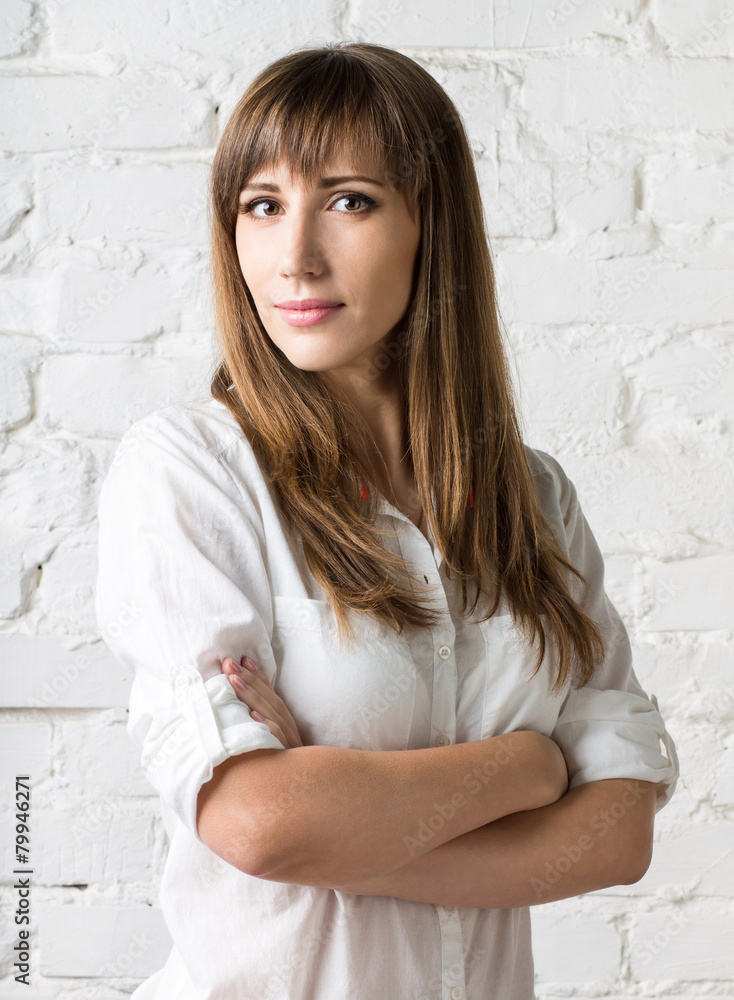 Young pretty woman standing against white brick wall. Young pretty woman standing against white brick wall.