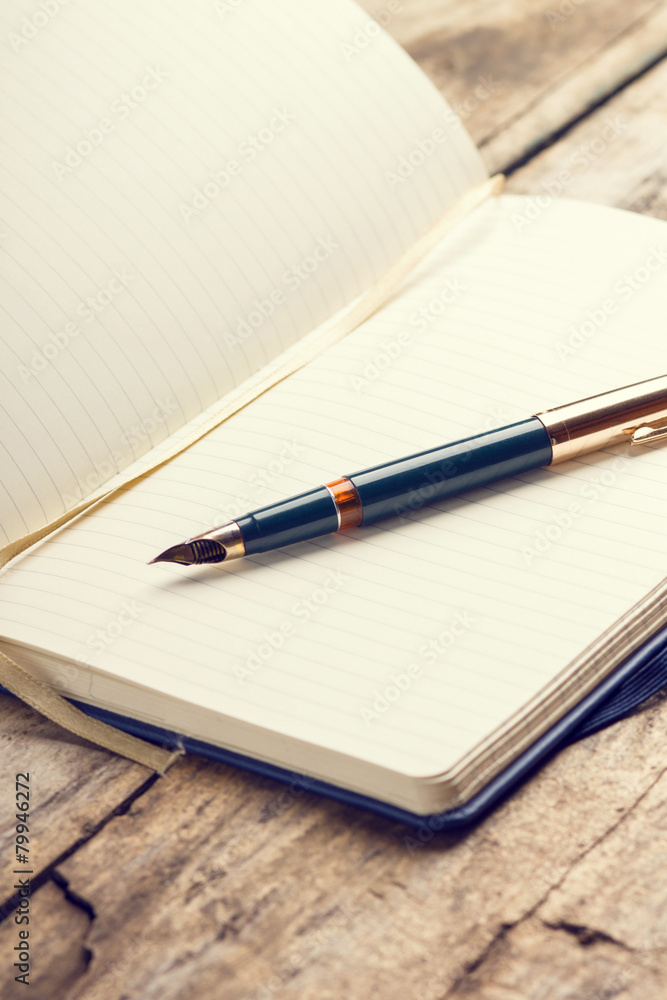 Opened blank notebook with elegant fountain pen Opened blank notebook with elegant fountain pen