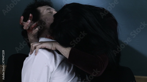 Female vampire sucking blood from dead man