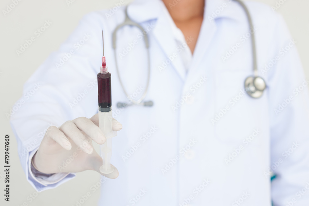 holding a syringe with blood holding a syringe with blood