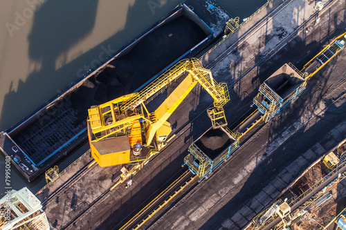 aerial view of moving crane with a heap of coal next to the coal