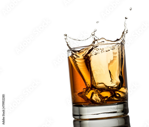 splash of whiskey with ice osolated on white background photo