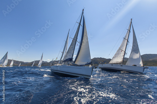 Sailing ships yachts with white sails in the open sea.