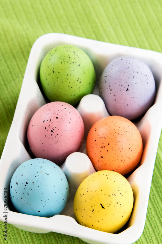 colored Easter eggs in white carton colored Easter eggs in white carton