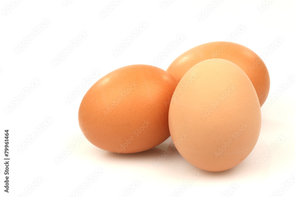 three brown eggs on a white background three brown eggs on a white background