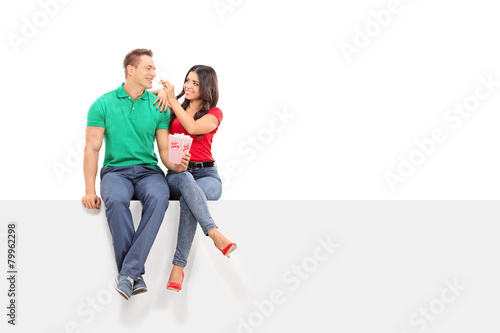 Woman feeding popcorn to her boyfriend