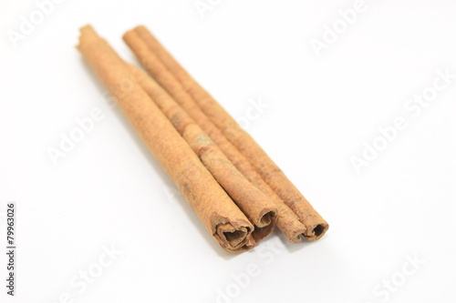 Cinnamon sticks stacked on white background.
