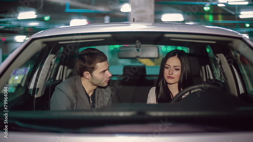 Emotions of a young couple in the car in the underground parking