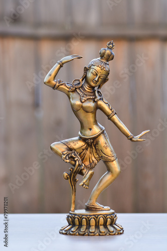Tara Avalokitesvara bodhisattva - indian statue  made of bronze  on wooden background