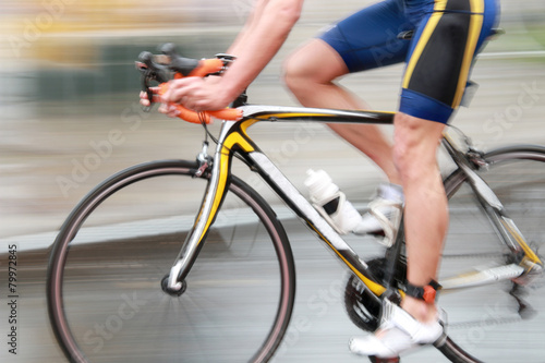 Fotografie Rapid blue bicycling man, sideview without torso