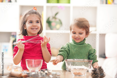 Cute little boy and girl having fun playing in the kitchen