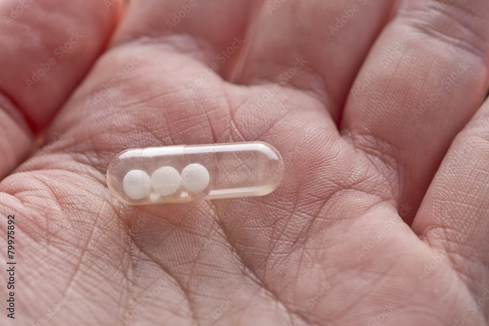 capsule pill with homeopathy in macro hand capsule pill with homeopathy in macro hand