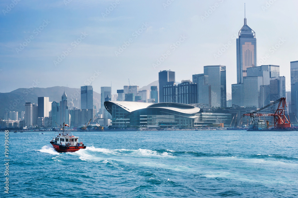 Obraz premium Red tug boat in front of Hong Kong skyline and panorama cityscape