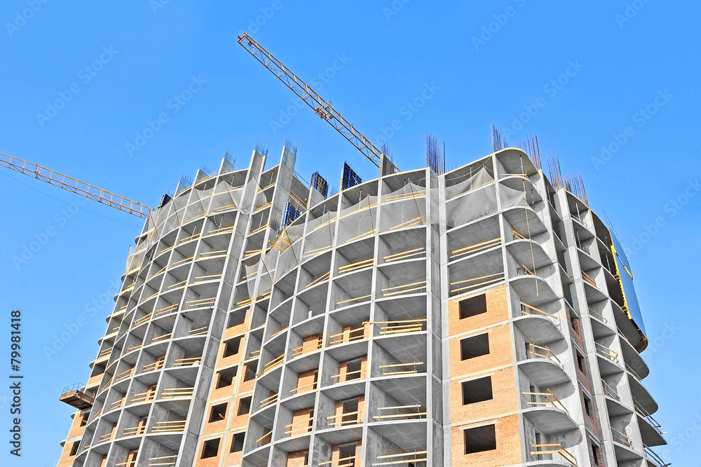Crane and building construction site against blue sky Crane and building construction site against blue sky
