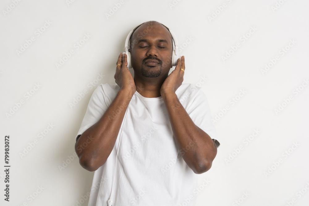 Indian young man with headphone on plain background. Indian young man with headphone on plain background.
