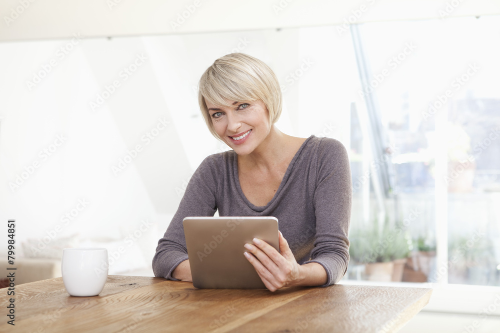 Germany, Bavaria, Munich, Woman using digital table at table, smiling, portrait Germany, Bavaria, Munich, Woman using digital table at table, smiling, portrait