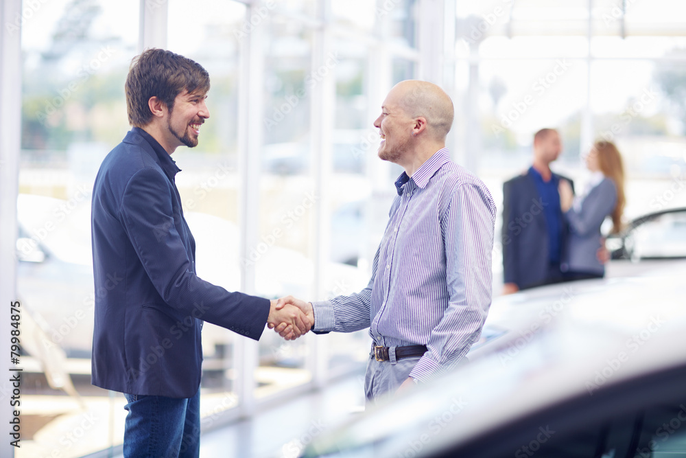 Car dealer and client shaking hands Car dealer and client shaking hands