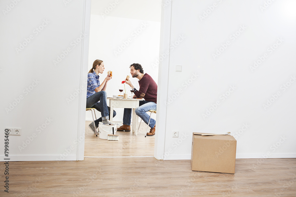 Couple eating pizza in new house Couple eating pizza in new house