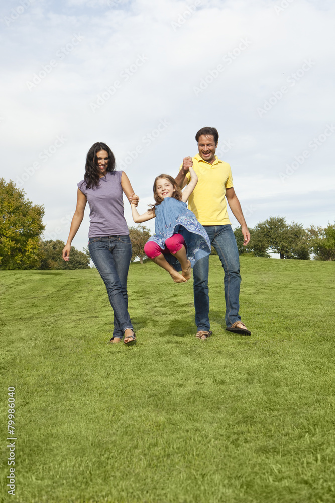 Germany, Bavaria, Parents playing with daughter in park, smiling Germany, Bavaria, Parents playing with daughter in park, smiling