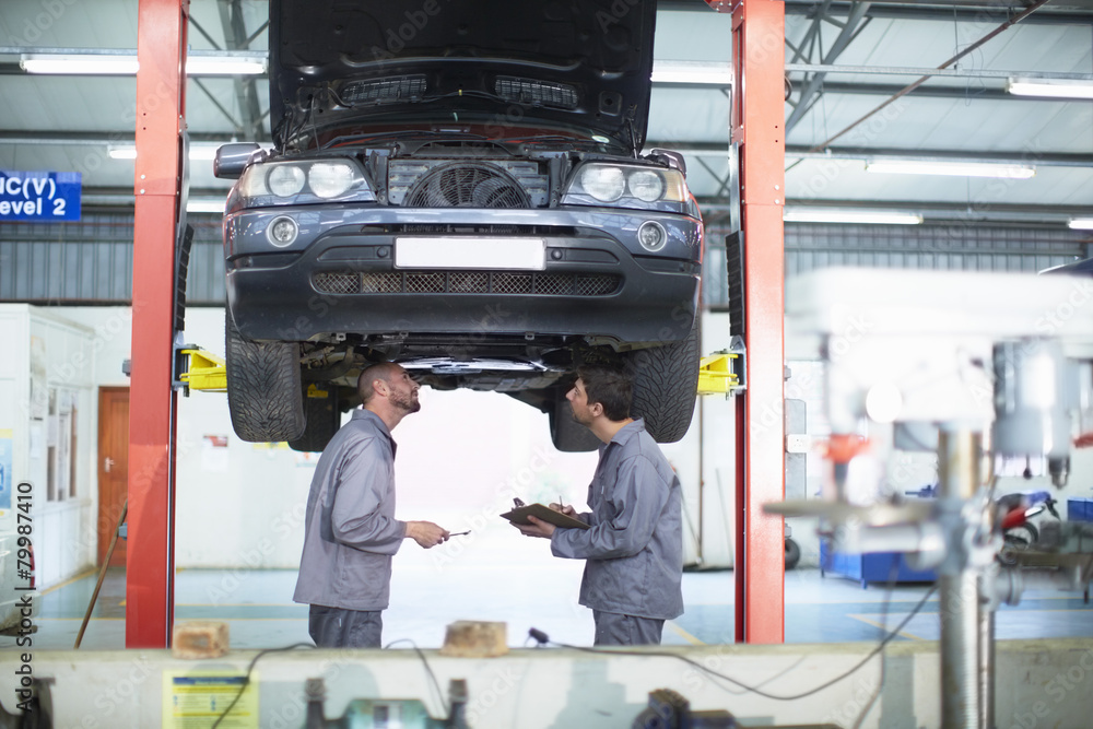 Two car mechanics at work in repair garage Two car mechanics at work in repair garage