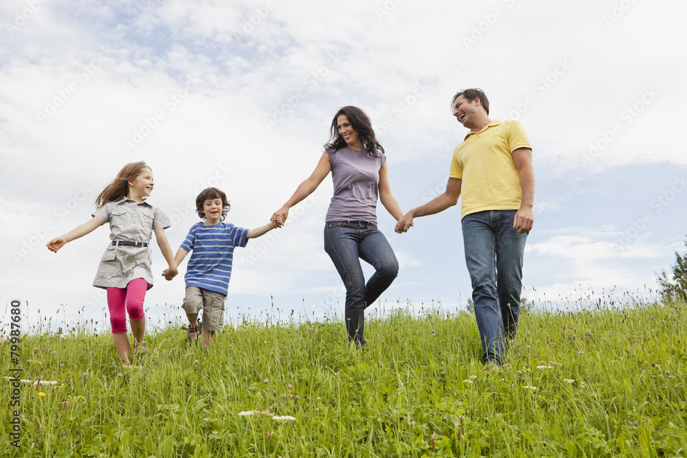 Germany, Bavaria, Family walking in grass at park Germany, Bavaria, Family walking in grass at park
