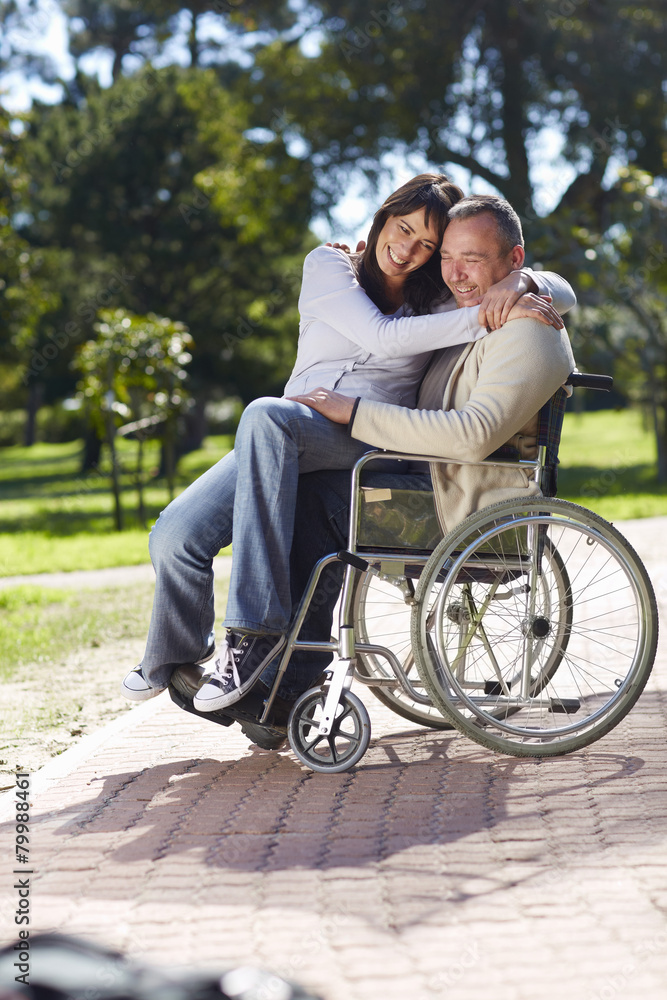 Woman hugging man in wheelchair Woman hugging man in wheelchair