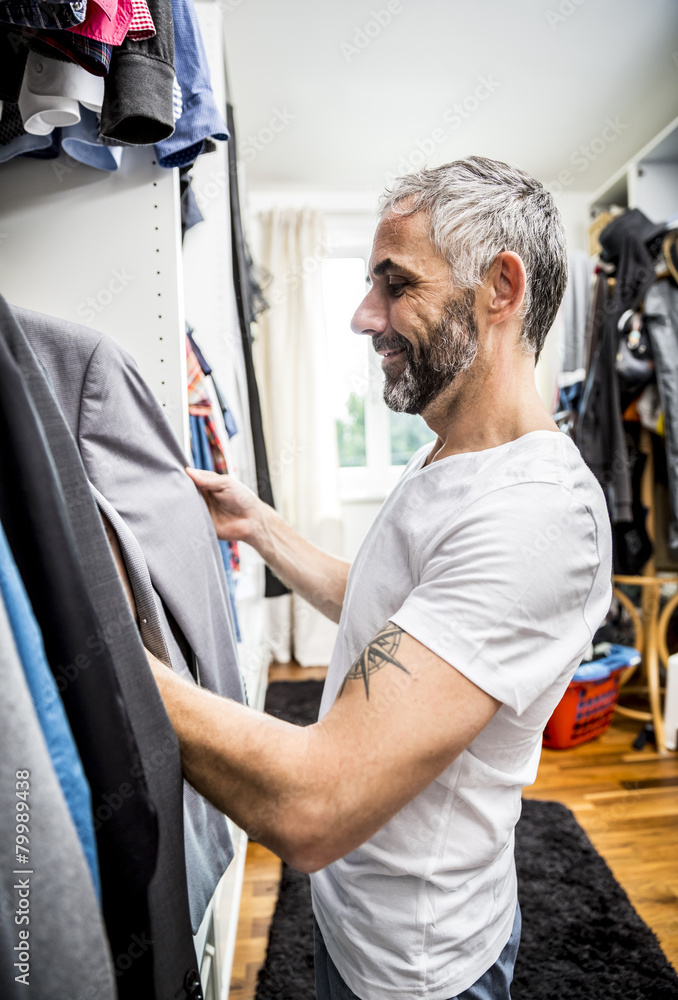 Man choosing clothes at his walk-in closet Man choosing clothes at his walk-in closet
